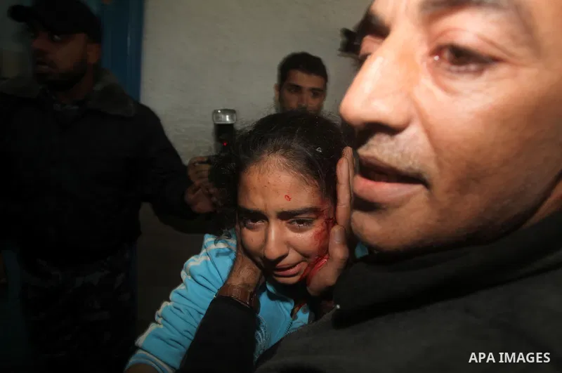 A Palestinian man carries a wounded girl on a stretcher to Al-Shifa hospital in Gaza City on November 18, 2012. An Israeli air strike hit a Gaza City media building on November 18, injuring at least six journalists, as a...