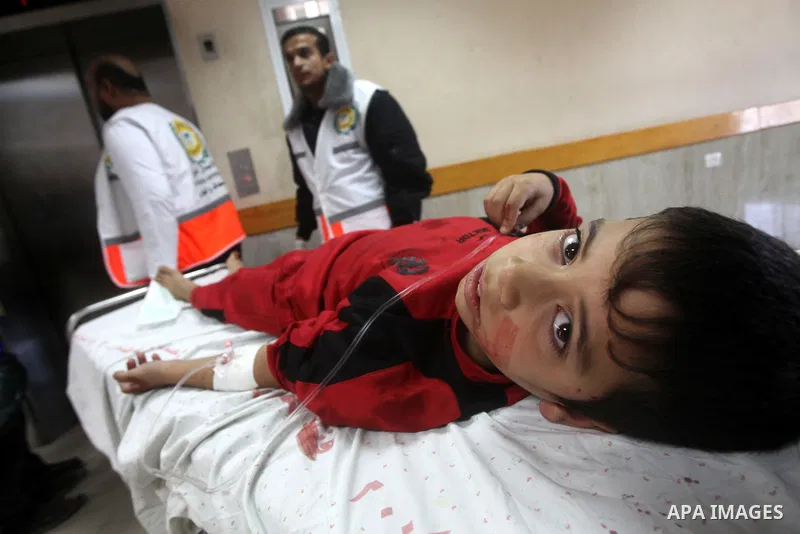 Palestinian medics wheel a wounded boy on a stretcher to Al-Shifa hospital in Gaza City on November 18, 2012. An Israeli air strike hit a Gaza City media building on November 18, injuring at least six journalists, as a s...