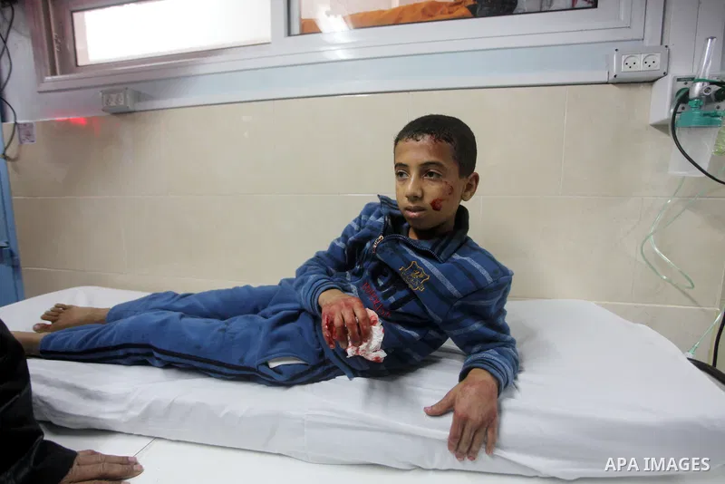 A Palestinian wounded boy arrives to Al-Shifa hospital in Gaza City on November 18, 2012. An Israeli air strike hit a Gaza City media building on November 18, injuring at least six journalists, as a separate raid in nort...