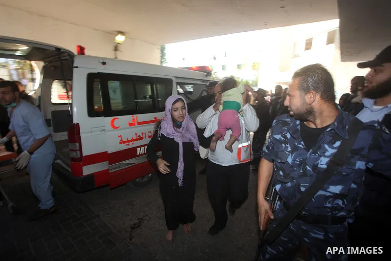 A Palestinian man carries a wounded baby on a stretcher to Al-Shifa hospital in Gaza City on November 18, 2012. An Israeli air strike hit a Gaza City media building on November 18, injuring at least six journalists, as a...