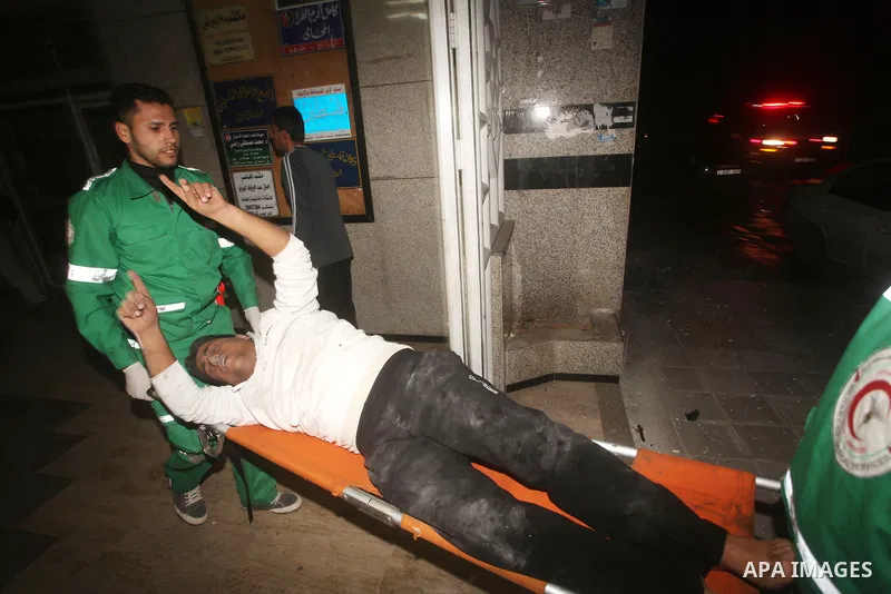 Palestinian medics wheel a wounded man on a stretcher to Al-Shifa hospital in Gaza City on November 18, 2012. An Israeli air strike hit a Gaza City media building on November 18, injuring at least six journalists, as a s...