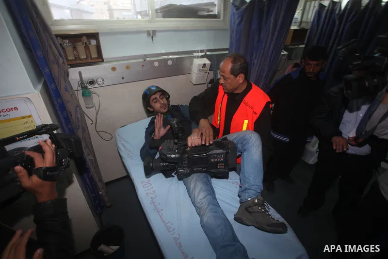 Palestinian medics treat a wounded Journalist on a stretcher to Al-Shifa hospital in Gaza City on November 18, 2012. An Israeli air strike hit a Gaza City media building on November 18, injuring at least six journalists,...