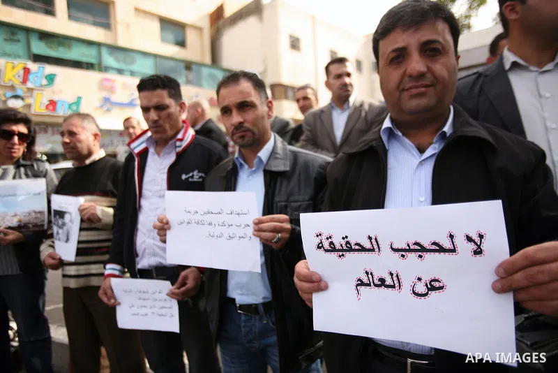 Palestinian Journalists hold placards during a protest against the Israeli military attacks on the palestinian Gaza strip, in the West Bank town of Hebron, on November 18, 2012. An Israeli air strike hit a Gaza City medi...