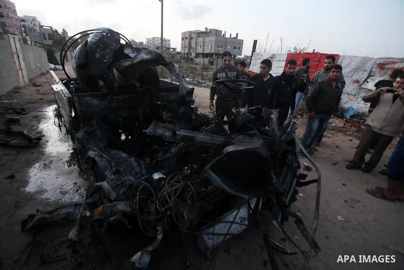 Palestinians gather arround a destroyed drinking water car which targeted by Israeli aircraft in the Jabaliya refugee camp, north of Gaza City, on Nov. 18, 2012. Ten Palestinian civilians were killed on Sunday in an Isra...