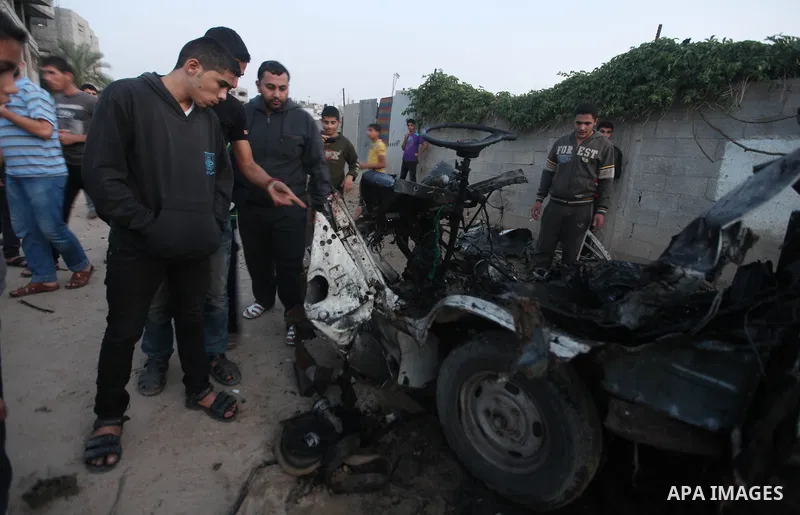 Palestinians gather arround a destroyed drinking water car which targeted by Israeli aircraft in the Jabaliya refugee camp, north of Gaza City, on Nov. 18, 2012. Ten Palestinian civilians were killed on Sunday in an Isra...