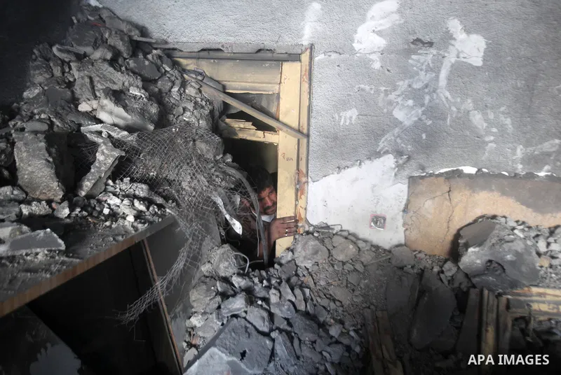 Palestinians search through the debris of the destroyed home of the al-Dallu family following an Israeli air strike in Gaza City, on November 18, 2012. Ten Palestinian civilians were killed on Sunday in an Israeli air st...