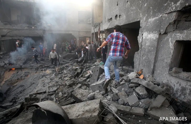 Palestinians search through the debris of the destroyed home of the al-Dallu family following an Israeli air strike in Gaza City, on November 18, 2012. Ten Palestinian civilians were killed on Sunday in an Israeli air st...
