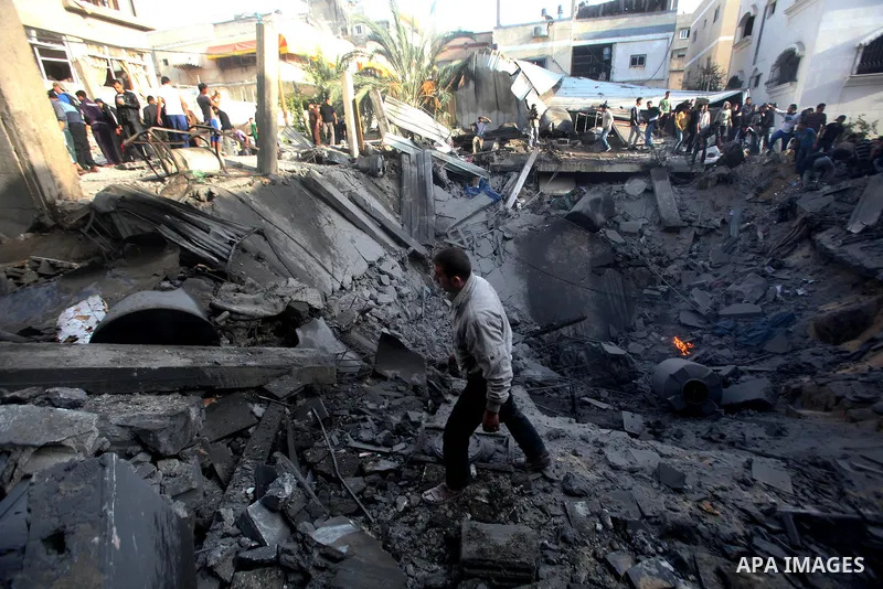 Palestinians search through the debris of the destroyed home of the al-Dallu family following an Israeli air strike in Gaza City, on November 18, 2012. Ten Palestinian civilians were killed on Sunday in an Israeli air st...