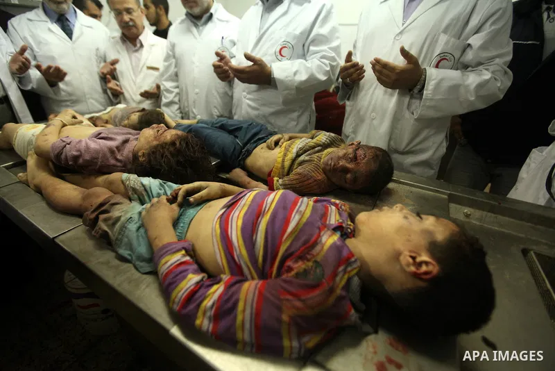 Palestinian doctors gather arround the bodies of four children from the al-Dallu family lay in a hospital after an Israeli missile struck a family home in Gaza City, on November 18, 2012. Ten Palestinian civilians were k...