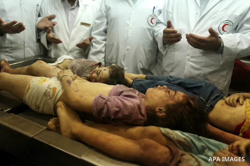 Palestinian doctors gather arround the bodies of four children from the al-Dallu family lay in a hospital after an Israeli missile struck a family home in Gaza City, on November 18, 2012. Ten Palestinian civilians were k...