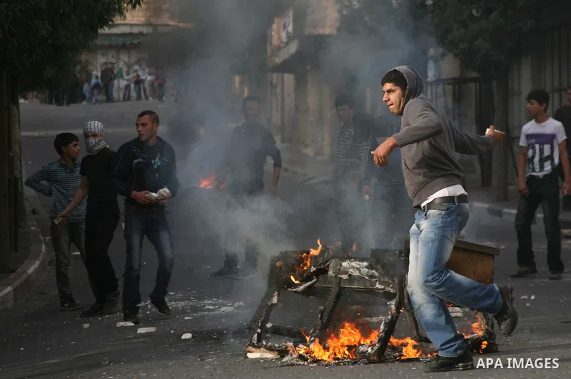 Palestinians in the West Bank city of Hebron protest by throwing stones against Israeli soldiers and security forces, 18 November 2012. Palestinians from the West Bank show their solidarity with Palestinians in the Gaza...