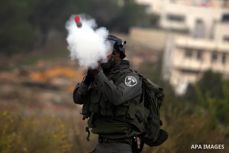 An Israeli border policeman shoots a tear gas canister at Palestinian protesters during clashes outside Ofer prison near the West Bank city of Ramallah November 18, 2012. The clashes broke out following a protest against...