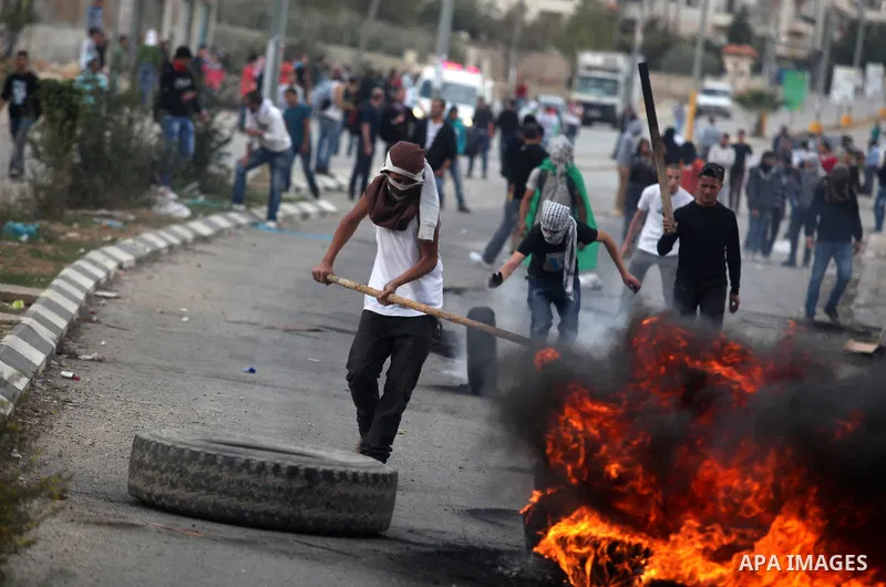 Palestinian protesters burn tires during clashes outside Ofer prison near the West Bank city of Ramallah November 18, 2012. The clashes broke out following a protest against Israel's military operation in the Gaza Strip....