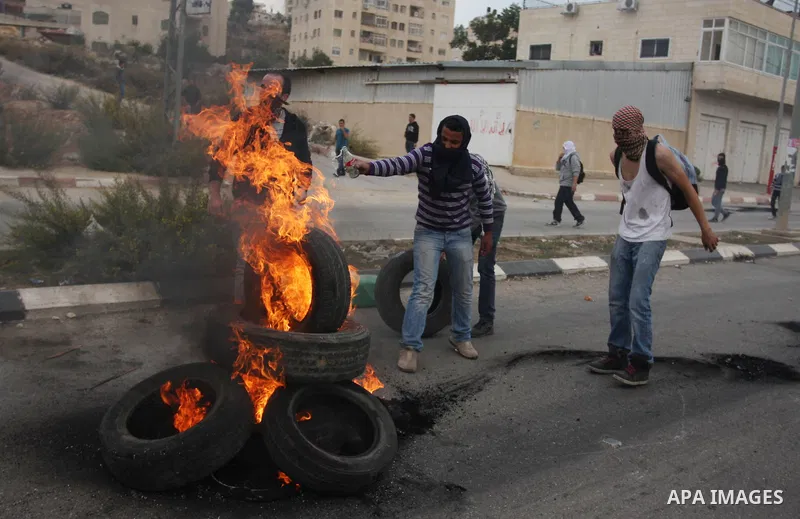 Palestinian protesters burn tires during clashes outside Ofer prison near the West Bank city of Ramallah November 18, 2012. The clashes broke out following a protest against Israel's military operation in the Gaza Strip....