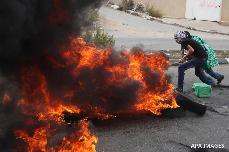 Palestinian protesters burn tires during clashes outside Ofer prison near the West Bank city of Ramallah November 18, 2012. The clashes broke out following a protest against Israel's military operation in the Gaza Strip....
