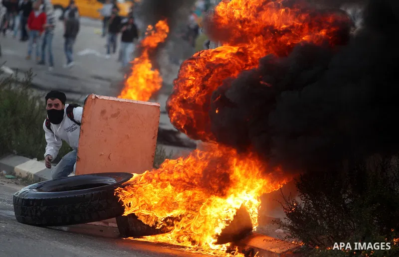 Palestinian protesters burn tires during clashes outside Ofer prison near the West Bank city of Ramallah November 18, 2012. The clashes broke out following a protest against Israel's military operation in the Gaza Strip....