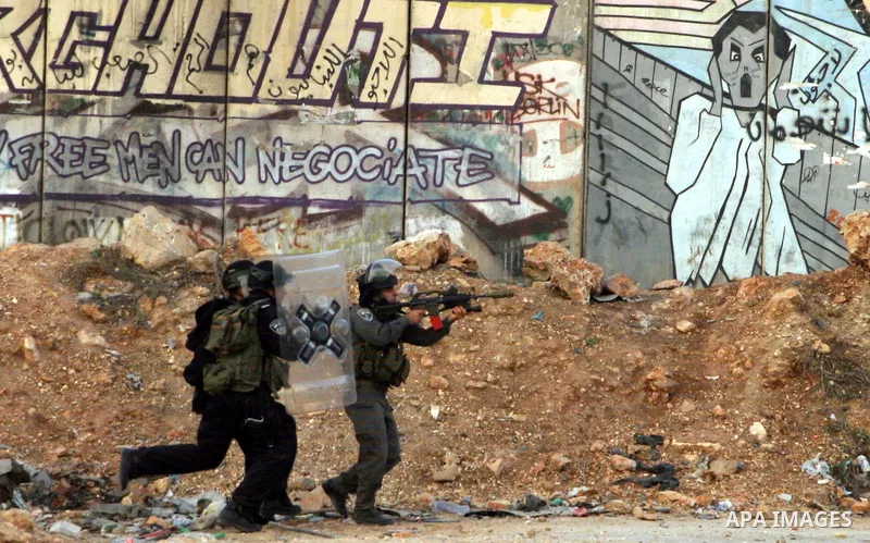 An Israeli border policeman shoots a tear gas canister at Palestinian protesters during a Palestinian protest at Damascus Gate in East Jerusalem, 18 November 2012, showing solidarity with the Palestinians in the Gaza Str...