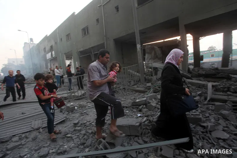 Palestinians walk amongst the debris of destroyed homes following an Israeli air strike in Gaza City, on November 19, 2012. Israeli air strikes on Sunday killed 31 Palestinians in the bloodiest day so far of its air camp...