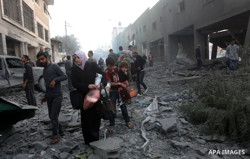 Palestinians walk amongst the debris of destroyed homes following an Israeli air strike in Gaza City, on November 19, 2012. Israeli air strikes on Sunday killed 31 Palestinians in the bloodiest day so far of its air camp...