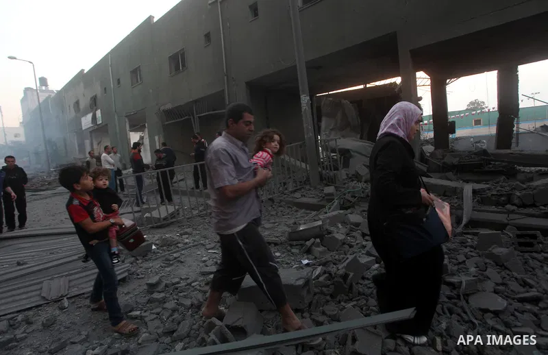 Palestinians walk amongst the debris of destroyed homes following an Israeli air strike in Gaza City, on November 19, 2012. Israeli air strikes on Sunday killed 31 Palestinians in the bloodiest day so far of its air camp...