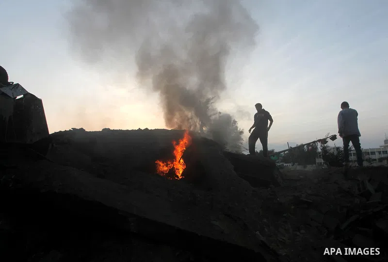 Palestinians try to extinguish a fire in a destroyed home following an Israeli air strike in Gaza City, on November 19, 2012. Israeli air strikes on Sunday killed 31 Palestinians in the bloodiest day so far of its air ca...