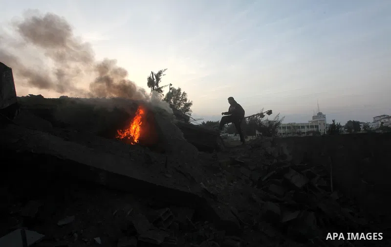 Palestinians try to extinguish a fire in a destroyed home following an Israeli air strike in Gaza City, on November 19, 2012. Israeli air strikes on Sunday killed 31 Palestinians in the bloodiest day so far of its air ca...