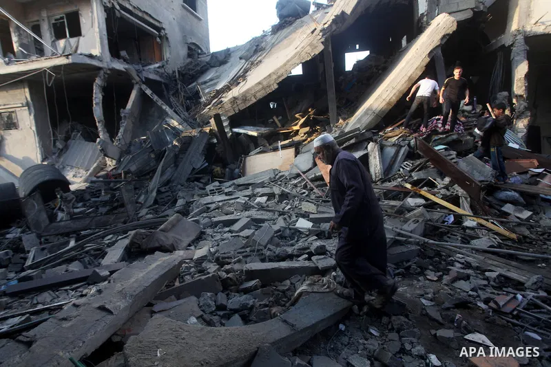 A Palestinian man walks amongst the debris of destroyed homes following an Israeli air strike in Gaza City, on November 19, 2012. Israeli air strikes on Sunday killed 31 Palestinians in the bloodiest day so far of its ai...