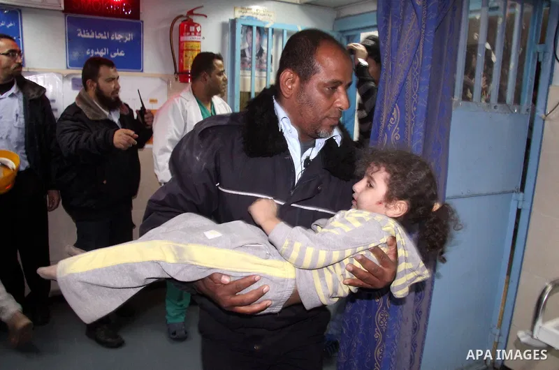 A Palestinian policeman carries a wounded baby girl at al-Shifa hospital after an Israeli air strike in Gaza city, on November 19, 2012. Israeli air strikes on Sunday killed 31 Palestinians in the bloodiest day so far of...