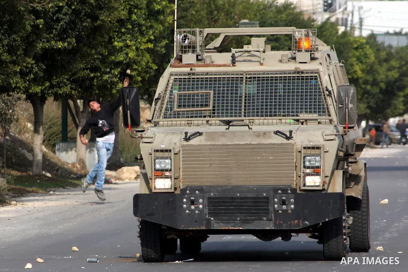 A Palestinian protester throws stones at Israeli soldiers during clashes following a protest against Israel's operations in the Gaza Strip, at Howwara checkpoint near Nablus, the West Bank, 17 November 2012. Reports stat...