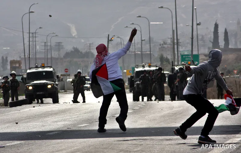 Palestinian protesters throw stones at Israeli soldiers during clashes following a protest against Israel's operations in the Gaza Strip, at Howwara checkpoint near Nablus, the West Bank, 17 November 2012. Reports state...