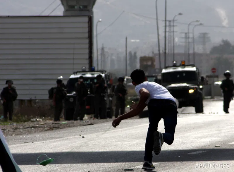 A Palestinian protester throws stones at Israeli soldiers during clashes following a protest against Israel's operations in the Gaza Strip, at Howwara checkpoint near Nablus, the West Bank, 17 November 2012. Reports stat...