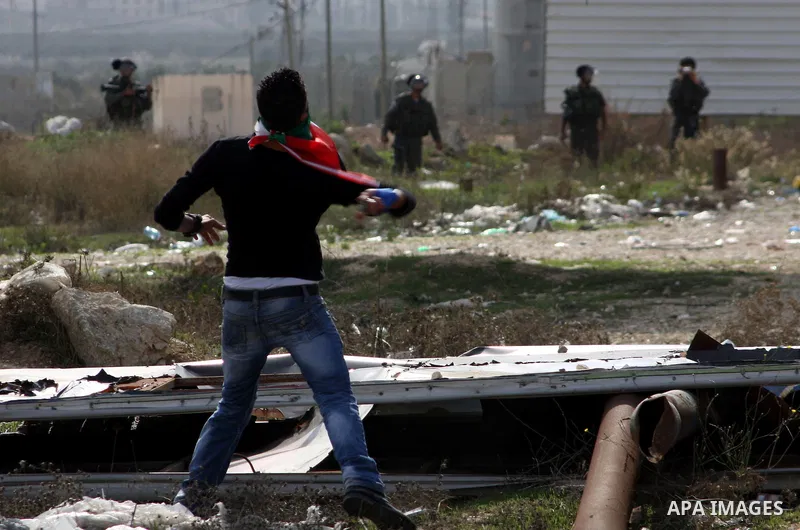 A Palestinian protester throws stones at Israeli soldiers during clashes following a protest against Israel's operations in the Gaza Strip, at Howwara checkpoint near Nablus, the West Bank, 17 November 2012. Reports stat...