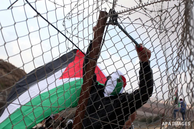 A Palestinian youth cut a section of Israel's separation fence in the West Bank village of Ramat near Ramallah to protest against Israel's military action on the Gaza Strip, on November 19, 2012 . Israeli air strikes acr...