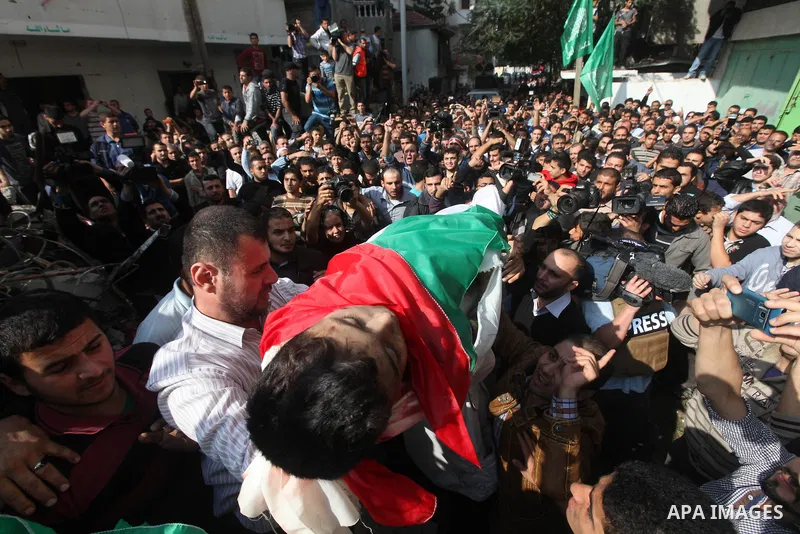 Palestinians carry the bodies of civilian from the al-Dallu family during their funeral in Gaza City, on November 19, 2012.Eleven members of the al-Dallu family were killed on Sunday when an Israeli missile struck the tw...