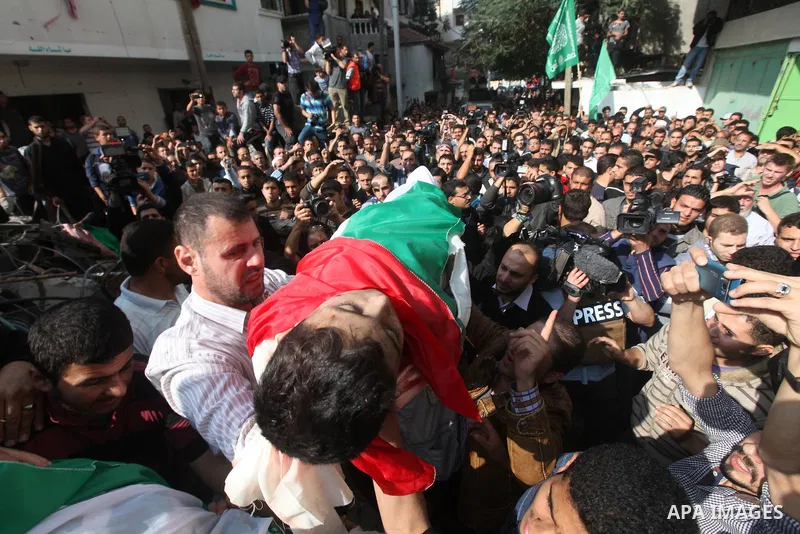 Palestinians carry the bodies of civilian from the al-Dallu family during their funeral in Gaza City, on November 19, 2012.Eleven members of the al-Dallu family were killed on Sunday when an Israeli missile struck the tw...