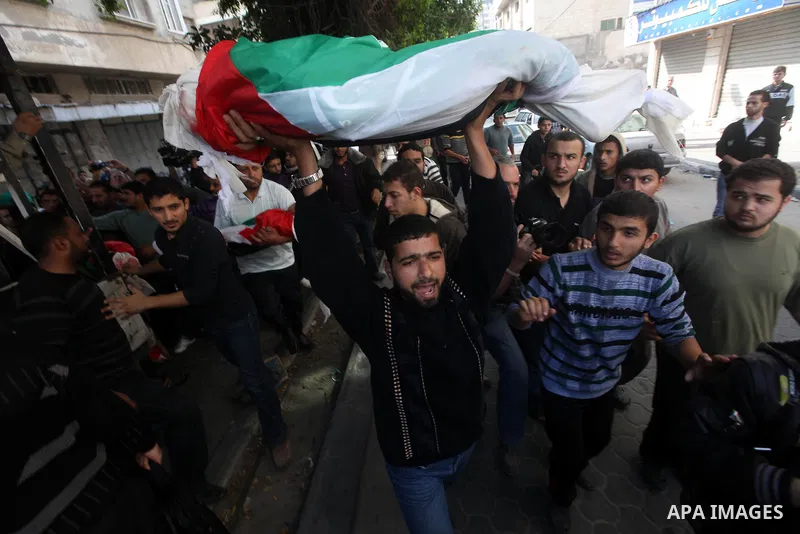 Palestinians carry the bodies of civilian from the al-Dallu family during their funeral in Gaza City, on November 19, 2012.Eleven members of the al-Dallu family were killed on Sunday when an Israeli missile struck the tw...