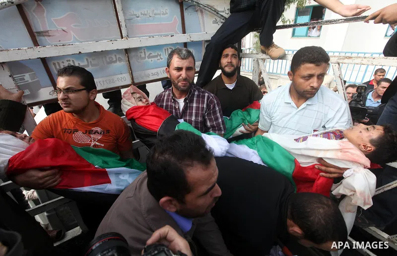 Palestinians carry the bodies of civilian from the al-Dallu family during their funeral in Gaza City, on November 19, 2012.Eleven members of the al-Dallu family were killed on Sunday when an Israeli missile struck the tw...