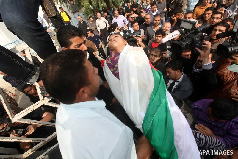 Palestinians carry the bodies of civilian from the al-Dallu family during their funeral in Gaza City, on November 19, 2012.Eleven members of the al-Dallu family were killed on Sunday when an Israeli missile struck the tw...