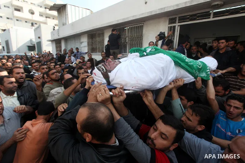 Palestinians carry the body of a member of Hamas militant Ezz el-Deen al-Qassam brigades during his funeral in Gaza City, on November 19, 2012. Media reports state that Israeli forces were on monday targeting the homes a...