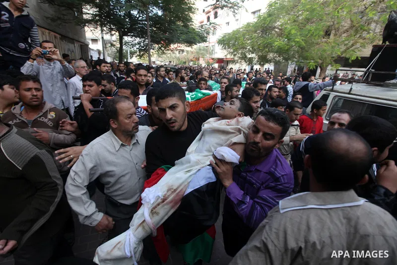 Palestinians carry the bodies of civilian from the al-Dallu family during their funeral in Gaza City, on November 19, 2012.Eleven members of the al-Dallu family were killed on Sunday when an Israeli missile struck the tw...