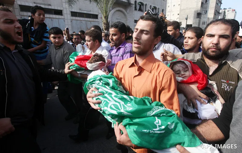 Palestinians carry the bodies of civilian from the al-Dallu family during their funeral in Gaza City, on November 19, 2012.Eleven members of the al-Dallu family were killed on Sunday when an Israeli missile struck the tw...