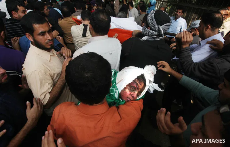 Palestinians carry the bodies of civilian from the al-Dallu family during their funeral in Gaza City, on November 19, 2012.Eleven members of the al-Dallu family were killed on Sunday when an Israeli missile struck the tw...