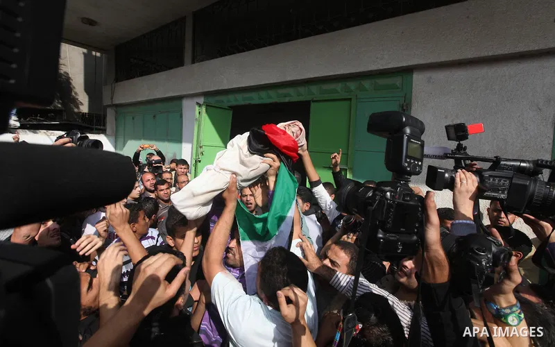 Palestinians carry the bodies of civilian from the al-Dallu family during their funeral in Gaza City, on November 19, 2012.Eleven members of the al-Dallu family were killed on Sunday when an Israeli missile struck the tw...