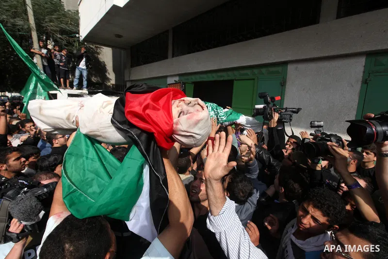 Palestinians carry the bodies of civilian from the al-Dallu family during their funeral in Gaza City, on November 19, 2012.Eleven members of the al-Dallu family were killed on Sunday when an Israeli missile struck the tw...