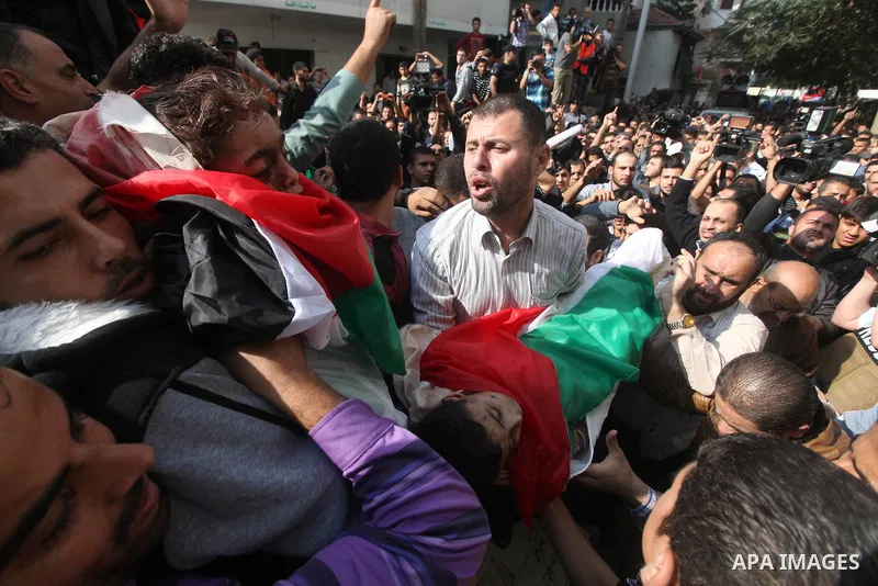 Palestinians carry the bodies of civilian from the al-Dallu family during their funeral in Gaza City, on November 19, 2012.Eleven members of the al-Dallu family were killed on Sunday when an Israeli missile struck the tw...