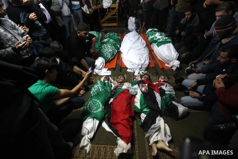 Palestinian mourners gather around the bodies of the al-Dallu family during their funeral in Gaza City, 19 November 2012. Nine members of the al-Dallu family died when Israeli forced hit their building in Gaza City one d...
