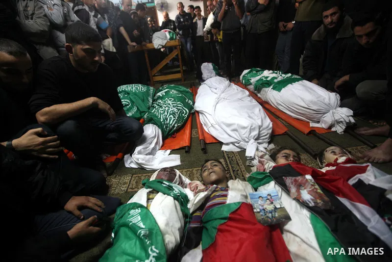 Palestinian mourners gather around the bodies of the al-Dallu family during their funeral in Gaza City, 19 November 2012. Nine members of the al-Dallu family died when Israeli forced hit their building in Gaza City one d...