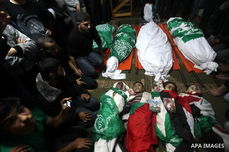 Palestinian mourners gather around the bodies of the al-Dallu family during their funeral in Gaza City, 19 November 2012. Nine members of the al-Dallu family died when Israeli forced hit their building in Gaza City one d...
