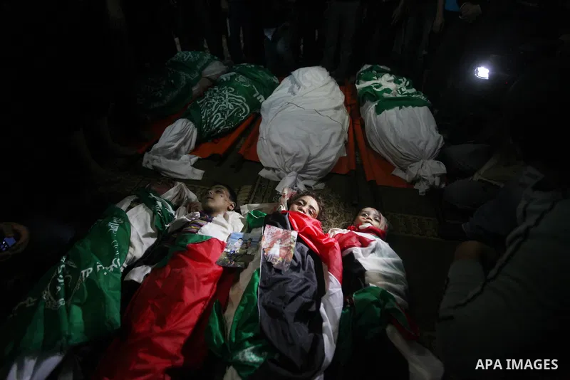 Palestinian mourners gather around the bodies of the al-Dallu family during their funeral in Gaza City, 19 November 2012. Nine members of the al-Dallu family died when Israeli forced hit their building in Gaza City one d...
