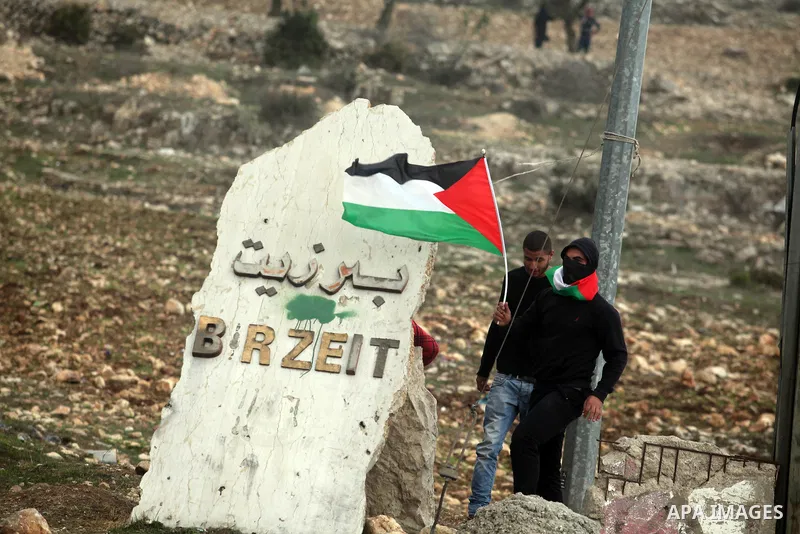 Palestinians take cover during minor clashes against Israel's military operation in the Gaza Strip, in the West Bank village of Birzeit, near Ramallah November 19, 2012. Israel bombed dozens of targets in Gaza on Monday...